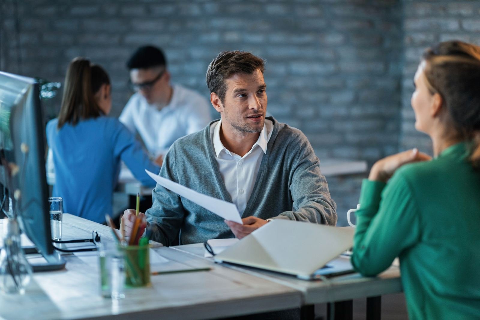 Two colleagues reviewing business reports together at an office desk